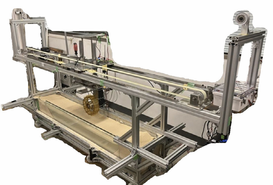 The Tohoku University Space Robotics Lab single wheel testbed. An aluminum-profile frame carries a horizontal carriage along a long, shallow sand bed with a transparent side wall.