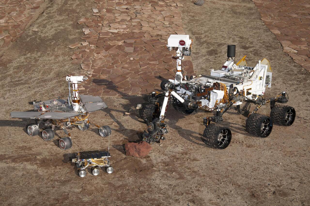 The JPL Mars Yard from the visitor platform, January 2012, with engineering models of Sojourner, a Mars Exploration Rover and Curiosity on the prepared soil bed.