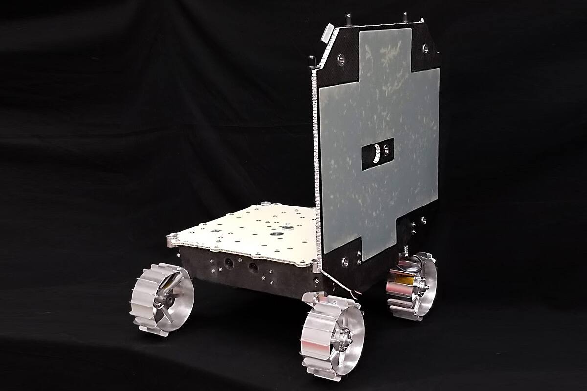 TerraMule, the MoonRanger structural and mobility build, with the single-sided solar panel in the deployed vertical position. The chassis is a carbon fiber monocoque shell closed by a machined aluminum top plate; the four wheels are fixed with no suspension, machined aluminum with integral grousers, and the stereo camera pair sits in the forward face of the chassis below the deck line