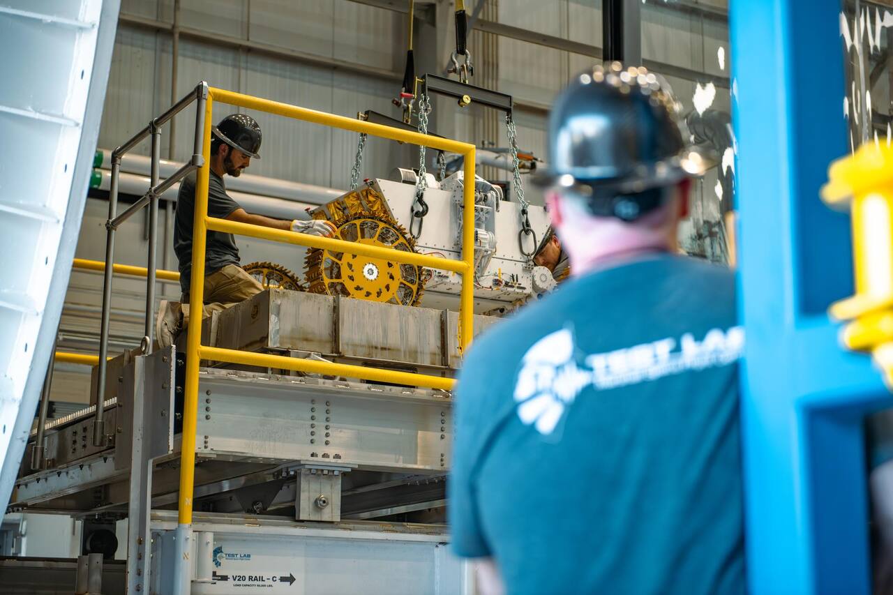 A Break the Ice Lunar Challenge excavation rover being positioned inside the V20 thermal vacuum chamber at the Marshall Environmental Test Facility, 30 July 2025, on the rail cart marked for a 60,000 lb load capacity.