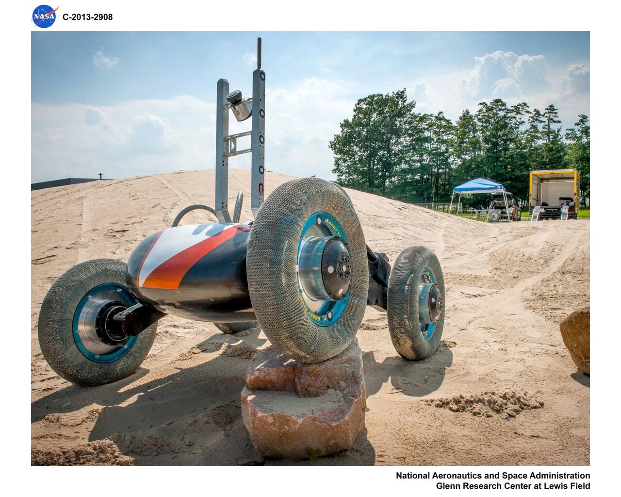 Scarab on the outdoor Simulated Lunar Operations dune at NASA GRC, 2009. The four independently driven 65 cm wheels sit on the differenced rocker suspension and the vertical structure carries both the drill and the navigation sensors