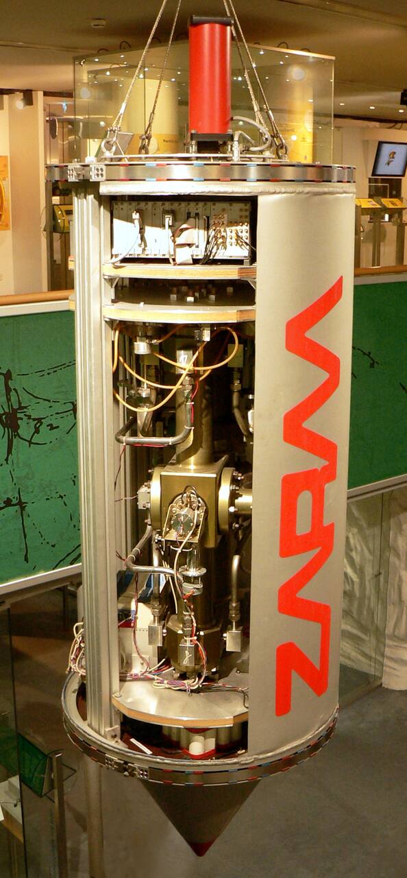 A ZARM drop capsule built in 1990, preserved as a museum exhibit at the Deutsches Museum Bonn rather than in service: the pressure shell, the stiffening ribs and the platform stack are those of the capsules still flown in the tube.